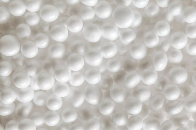 Close-up de diversas bolinhas brancas de poliestireno, representando o material EPS no colchão (Poliestireno Expandido) utilizado para estrutura e suporte