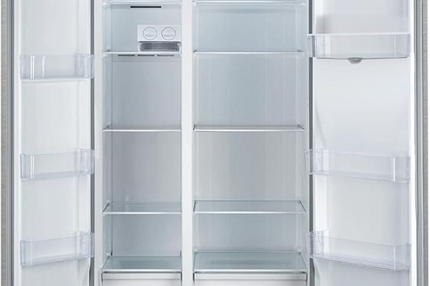 Interior de geladeira side by side aberta, com prateleiras de vidro e compartimentos nas portas