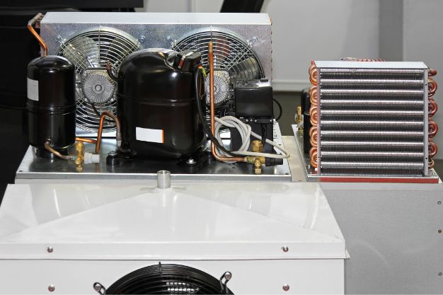 Componentes internos de uma geladeira inverter, com compressor e ventiladores. Sistema mostra a tecnologia de refrigeração com controle eletrônico contínuo. Imagem usada para explicar como funciona a geladeira inverter.
