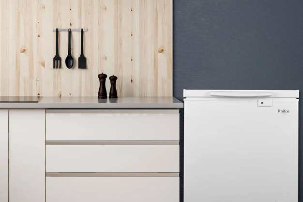 Freezer horizontal Philco branco ao lado de armários de cozinha