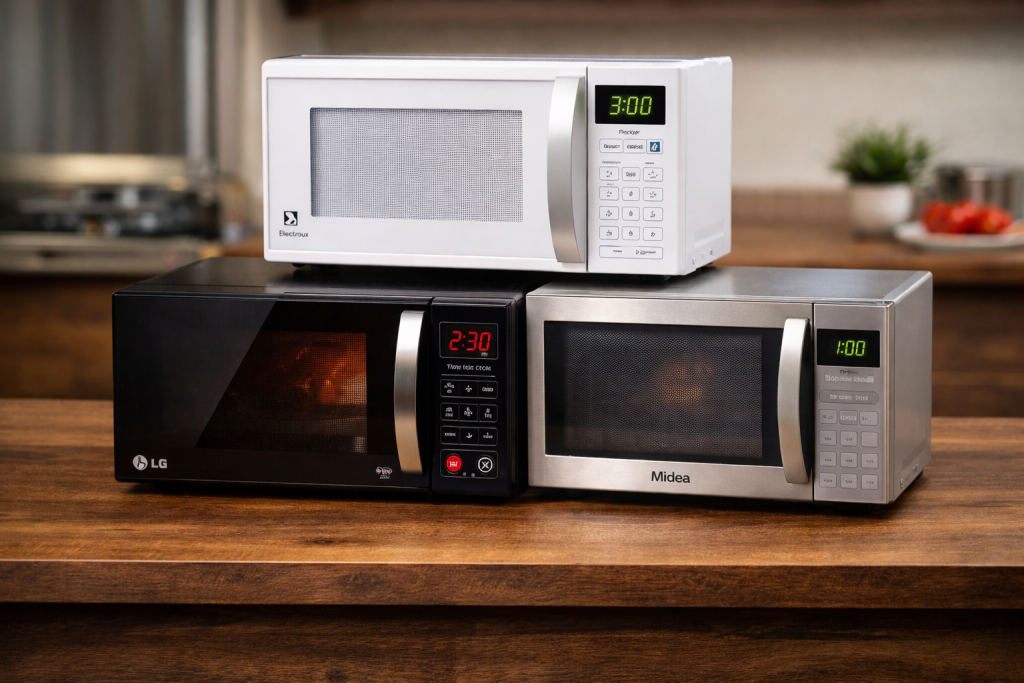 Três micro-ondas de marcas diferentes lado a lado sobre bancada para comparação de modelos
